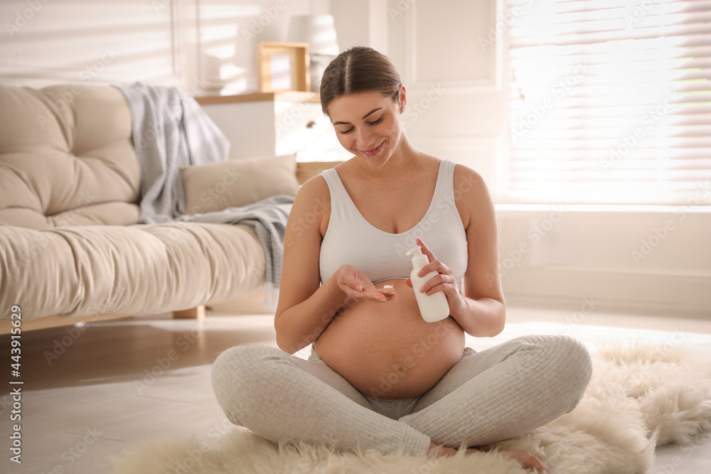 Young pregnant woman with cosmetic product at home Young pregnant woman with cosmetic product at home