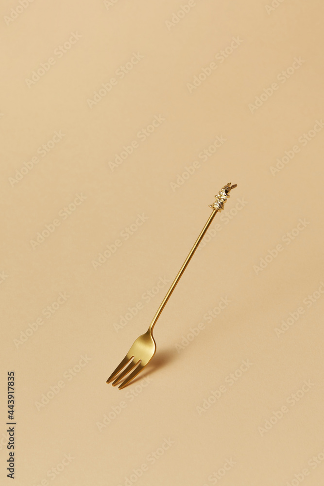 One small golden fork with rabbit on the handle One small golden fork with rabbit on the handle
