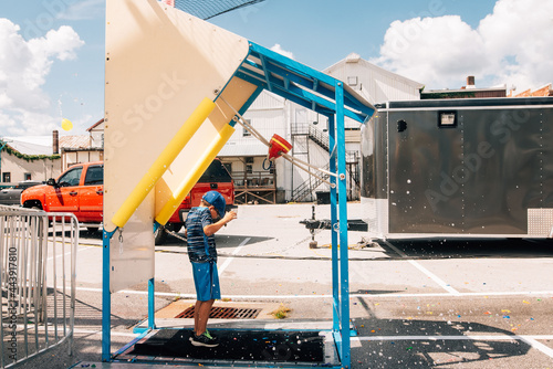 Child being splashed with water balloon. 