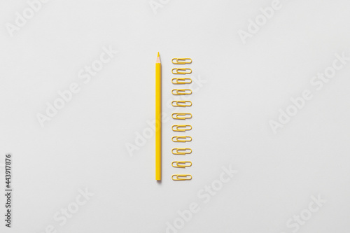 Yellow pencil and paper clips photo