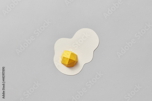 Papercraft yellow egg on gray background photo