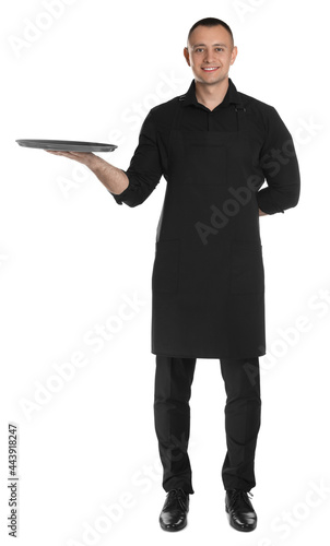Canvas Print Full length portrait of happy young waiter with tray on white background