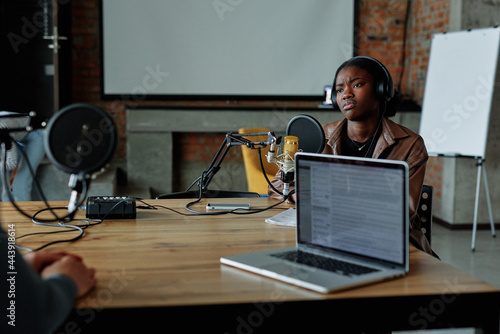 Podcaster discussing theme with coworker  photo