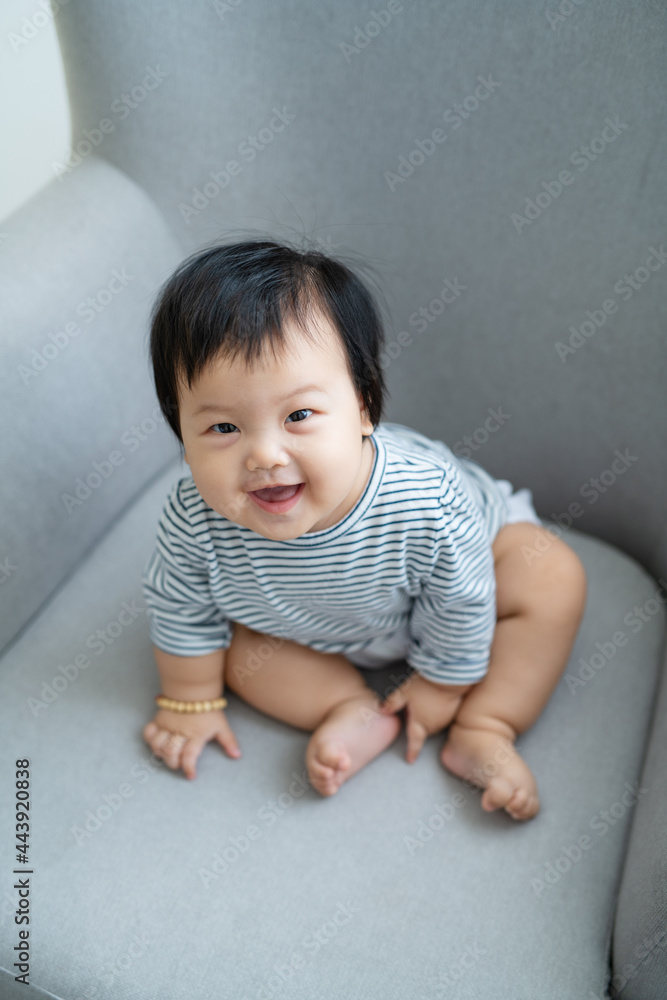 a baby girl sits on a sofa a baby girl sits on a sofa