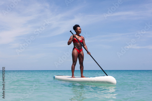 Focused woman standing on SUP board in sea photo