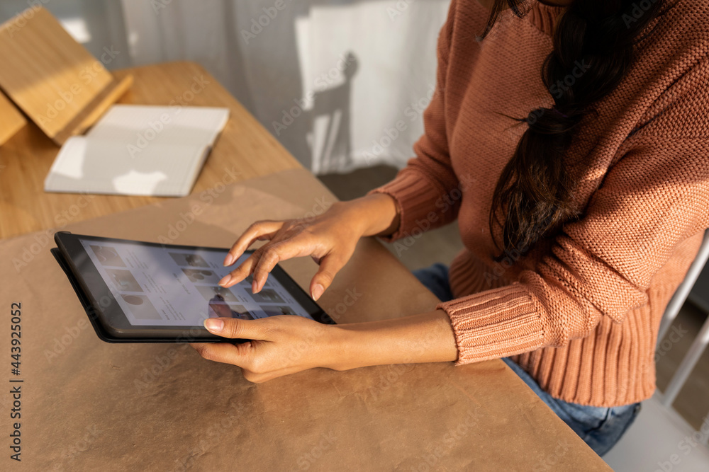 © Valentina Barreto/Stocksy - Close-up of woman using the tablet at office © Valentina Barreto/Stocksy - Close-up of woman using the tablet at office