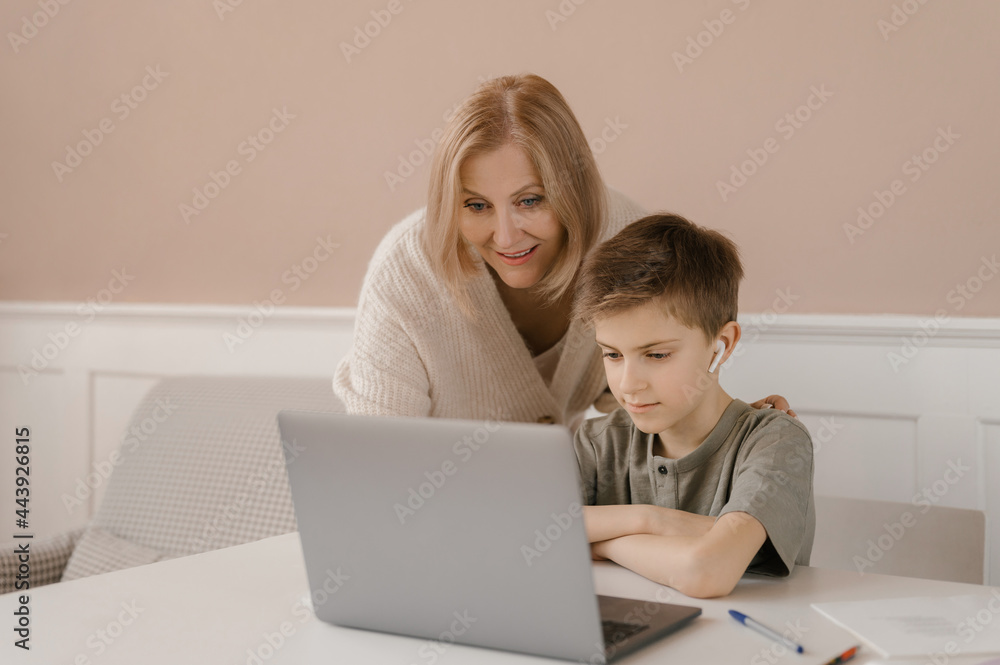 Mother and child doing homework together and using laptop Mother and child doing homework together and using laptop