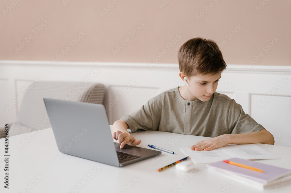 Teenager doing homework and using laptop Teenager doing homework and using laptop