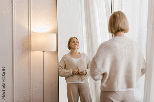 Middle aged woman looking at mirror photo