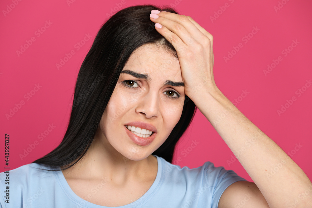 Woman suffering from migraine on pink background Woman suffering from migraine on pink background