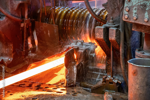 The rolling mill in operation. The hot metal is rolled through cooled rollers