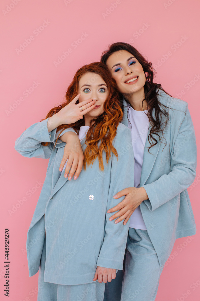 Happy women embracing in studio on pink background
Happy women embracing in studio on pink background