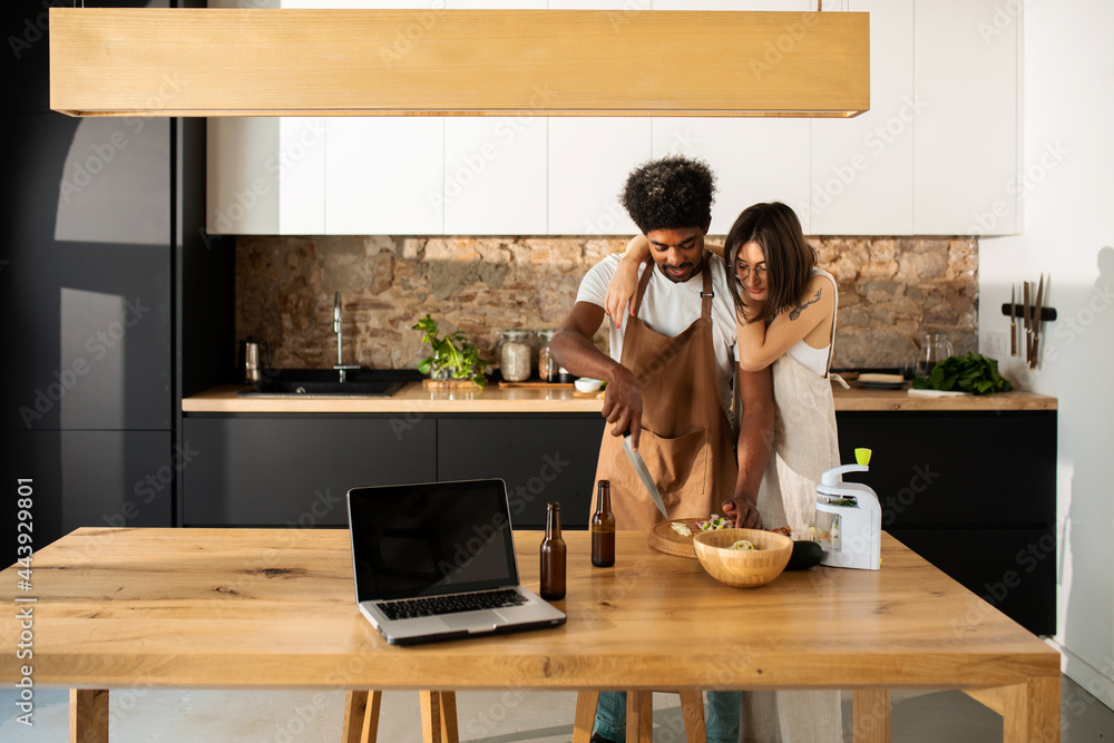 Young couple enjoying cooking together at cool kitchen Young couple enjoying cooking together at cool kitchen