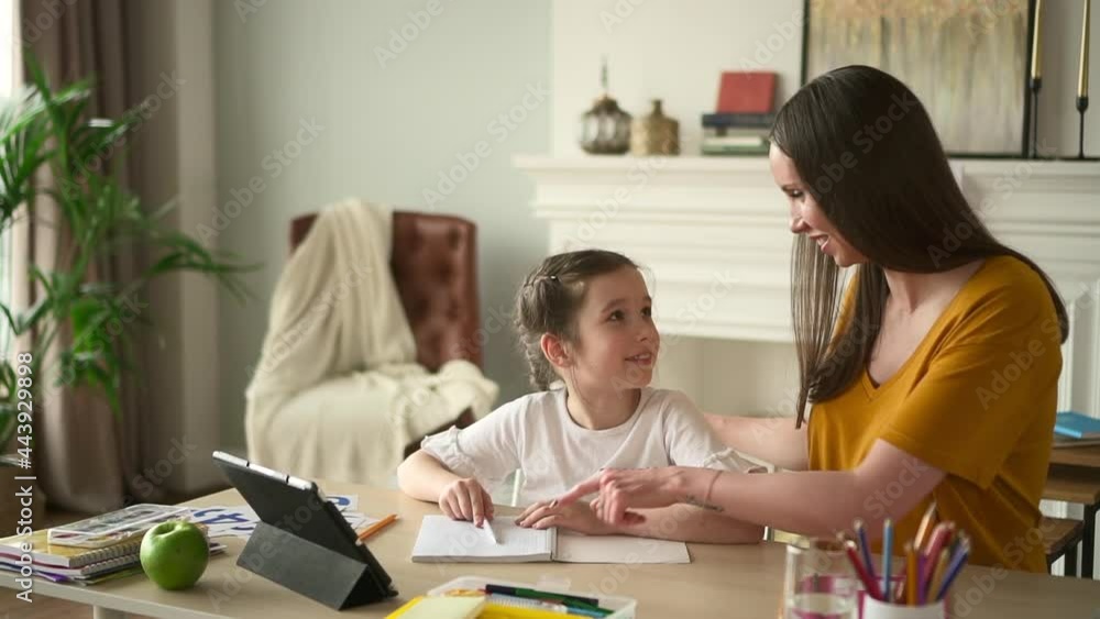 Homeschool online mother helps daughter do homework at table Spbd Homeschool online mother helps daughter do homework at table Spbd