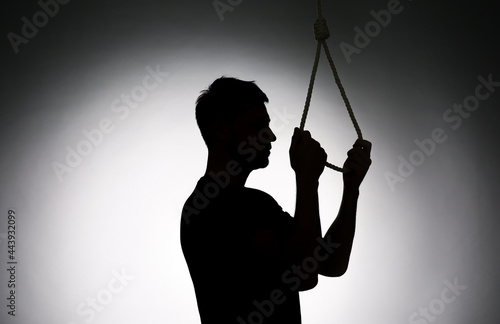 Fotografía Silhouette of man with rope noose on light background