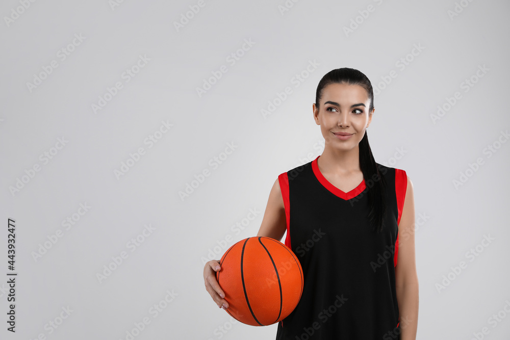 Basketball player with ball on grey background. Space for text