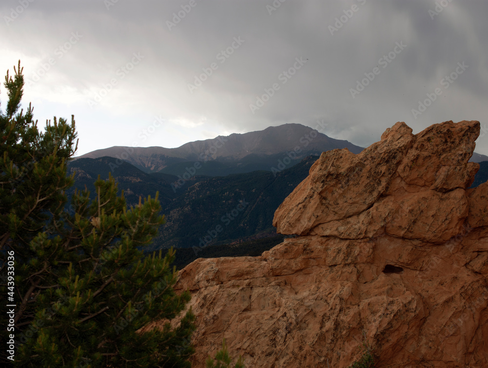 Mountain landscape with red boulders in the foreground.
