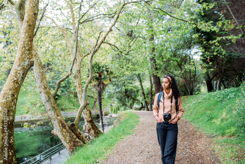 Stylish young black woman walking in park and enjoying scenic views photo