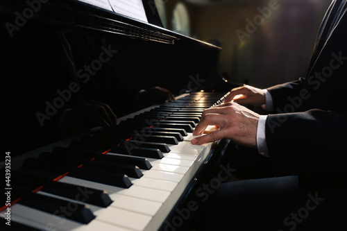 Man playing piano indoors, closeup. Talented musician