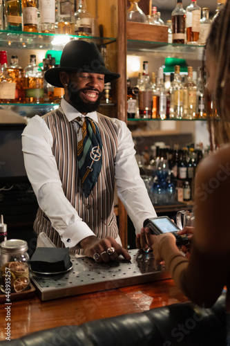Cheerful bartender waiting for client to enter pin code