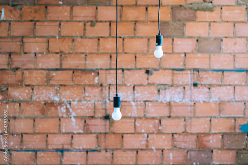 Light bulbs hanging on a brick wall
 photo