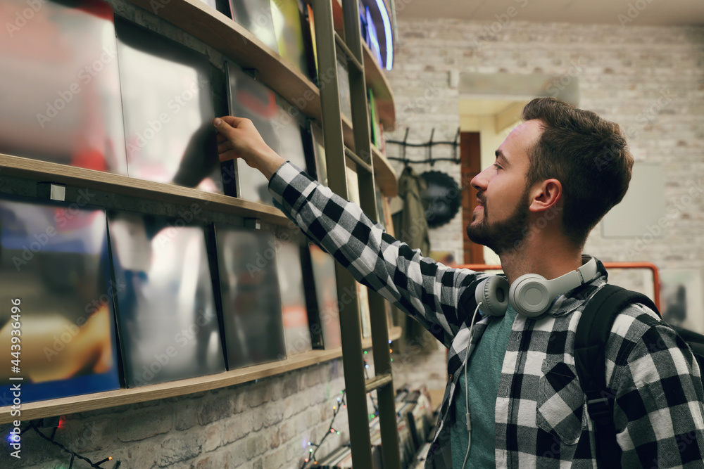 Young man choosing vinyl records in store