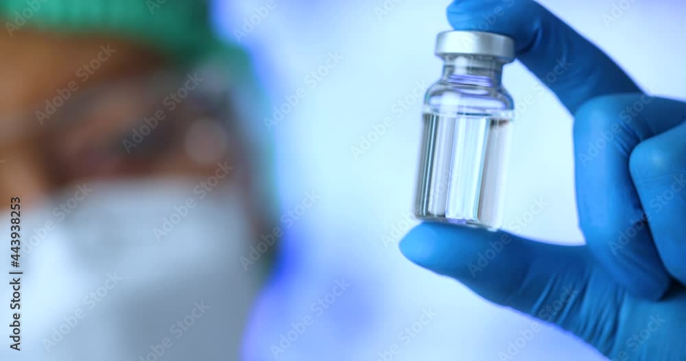 Close-up of scientist or doctor holding a vaccine vial in research medical lab Close-up of scientist or doctor holding a vaccine vial in research medical lab