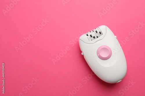 Modern epilator on pink background, top view. Space for text