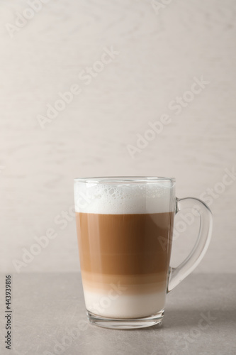 Hot coffee with milk in glass cup on light table