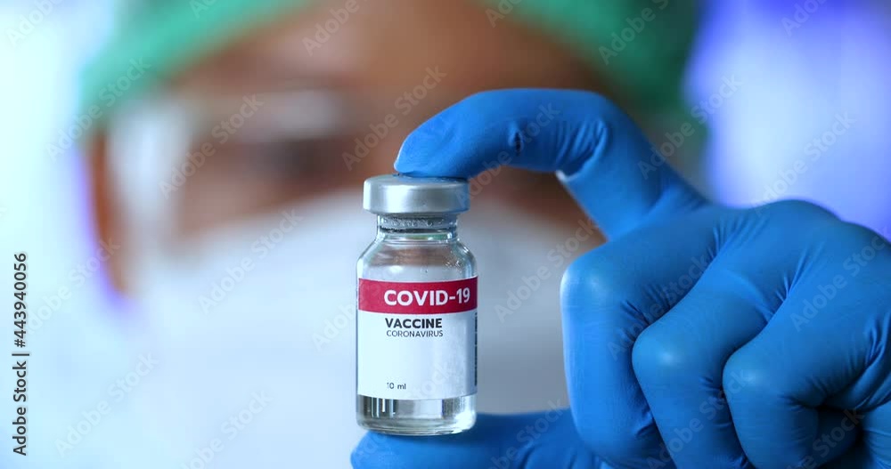 Close-up of scientist or doctor holding a covid-19 coronavirus vaccine vial in research medical lab Close-up of scientist or doctor holding a covid-19 coronavirus vaccine vial in research medical lab