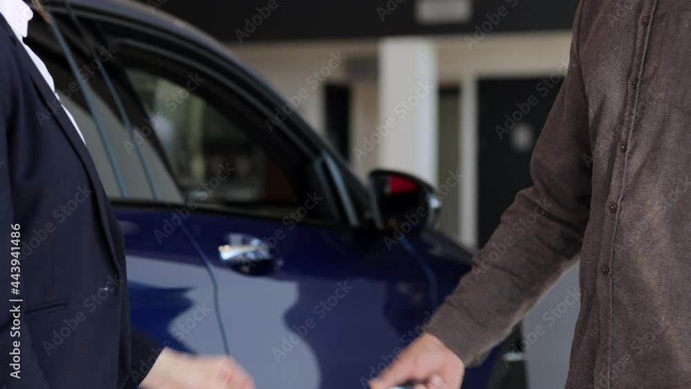 Manager in business suit gives vehicle key to car buyer Spbi Manager in business suit gives vehicle key to car buyer Spbi