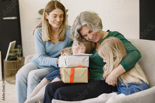 Family is sitting on the sofa and have a boxes with presents