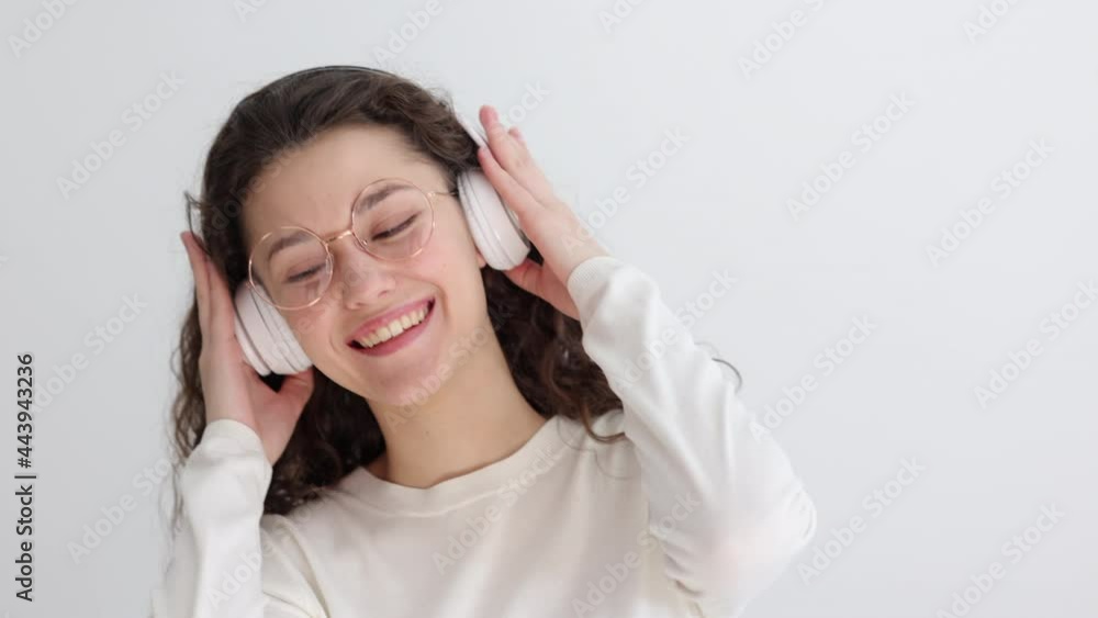 Young music lover lady enjoys music on light background Spbi Young music lover lady enjoys music on light background Spbi