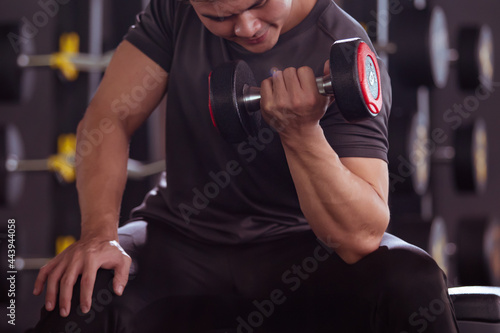 Asian young man practice weight training workout in the gym, body building exercise. 