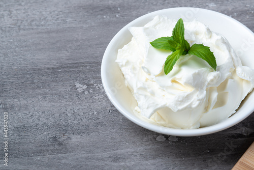 Bowl with fresh cottage cheese on a wooden table