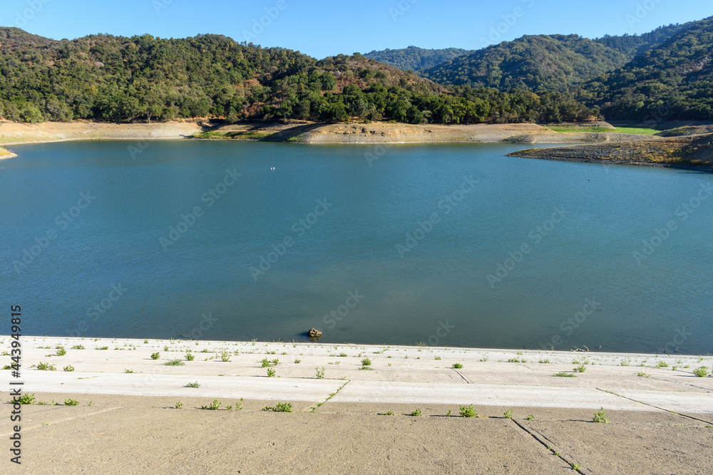 Looking down from the concrete wall of dam on almost dried with low water lever Stevens Creek reservoir in San Francisco Bay Area, California Looking down from the concrete wall of dam on almost dried with low water lever Stevens Creek reservoir in San Francisco Bay Area, California