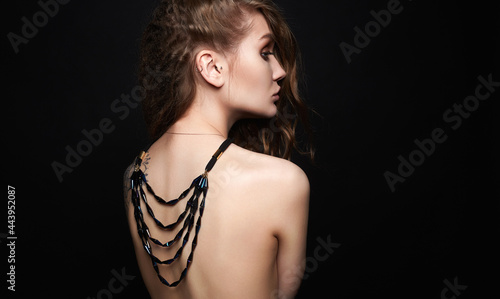 beautiful young woman with necklace on her naked back