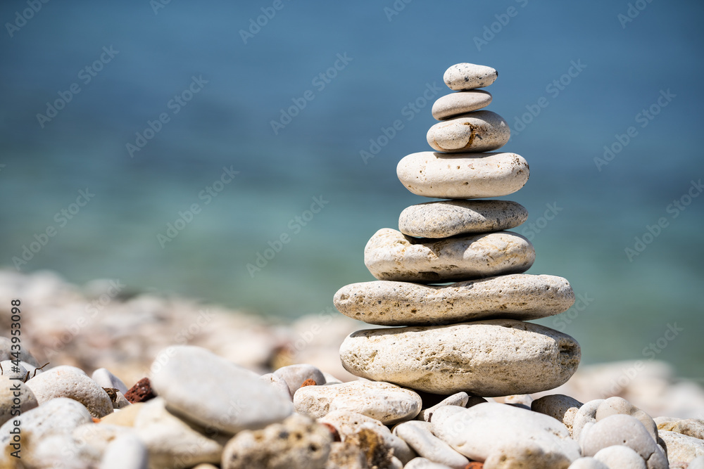 Balancing pebble figurine on the seashore. The concept of meditation and pacification. Close-up.