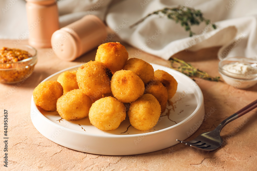 Plate with fried potato balls on color background Plate with fried potato balls on color background