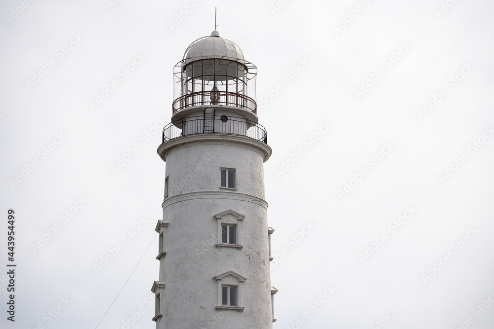 Close-up of a lighthouse on the background of a cloudy sky. Marine theme. Ocean coast. Close-up of a lighthouse on the background of a cloudy sky. Marine theme. Ocean coast.