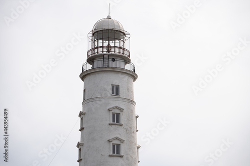 Close-up of a lighthouse on the background of a cloudy sky. Marine theme. Ocean coast.