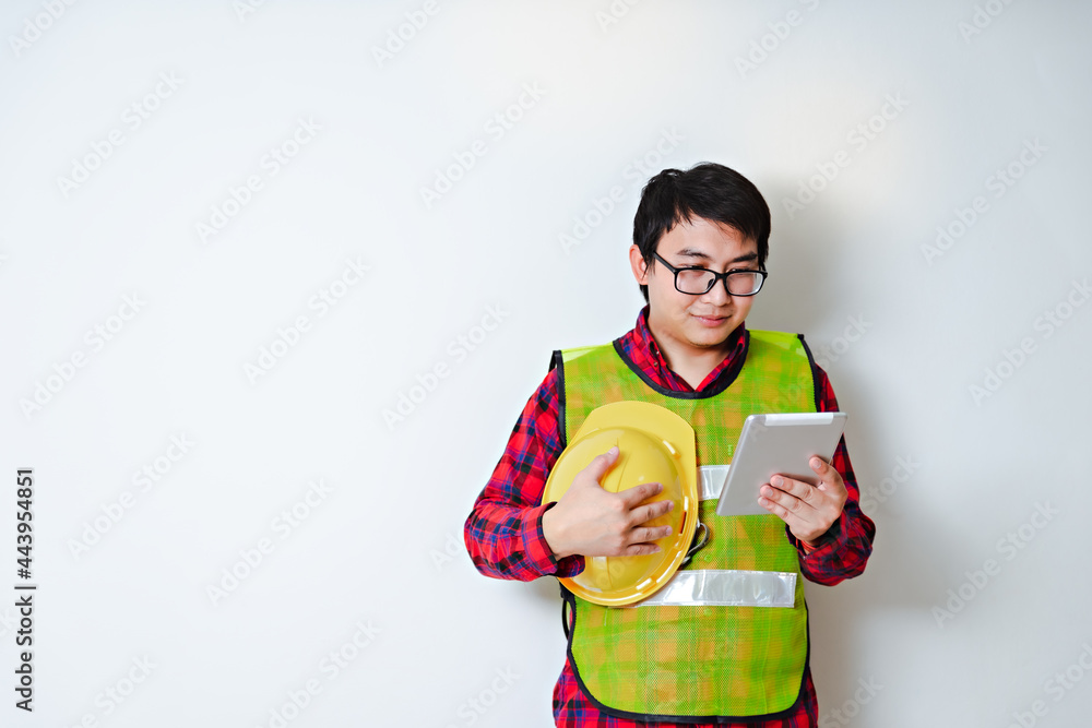 Asian men wear safety equipment holding tablet. Renovating technician during work. Asian men wear safety equipment holding tablet. Renovating technician during work.