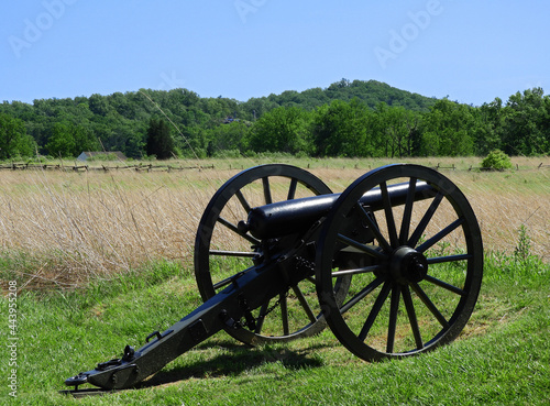 civil war cannon along hancock avenue on cemetery ridge on a sunny day  in the historic gettysburg battlefield  in gettysburg, pennsylvania, with little round top  mountain in the background photo