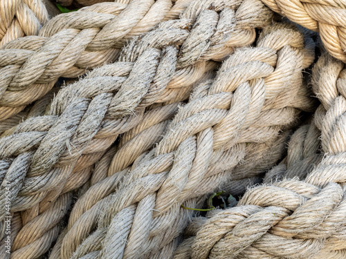 Thick braided rope is tied with a skein. Fishing rope background. photo