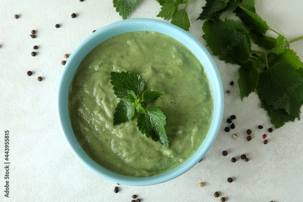 Concept of healthy food with nettle soup on white textured table Concept of healthy food with nettle soup on white textured table