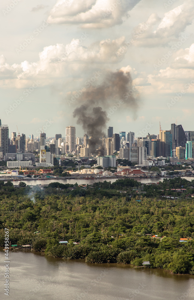 Bangkok, Thailand - 04 Jul, 2021 : Plume of smoke clouds from burnt building on fire at some area in the city. Fire disaster accident, Selective focus.