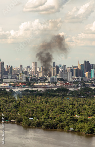 Bangkok, Thailand - 04 Jul, 2021 : Plume of smoke clouds from burnt building on fire at some area in the city. Fire disaster accident, Selective focus. © num