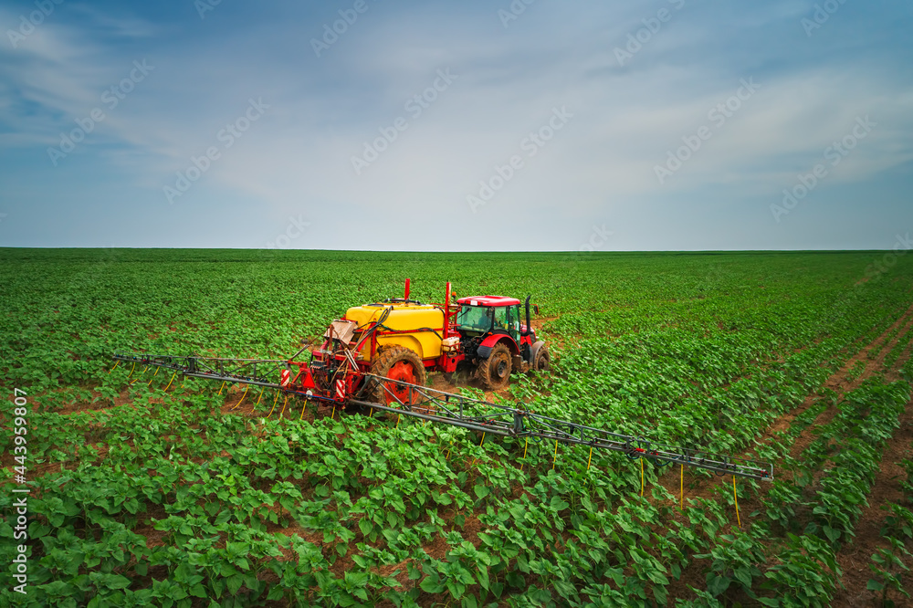Farming tractor plowing and spraying on field Farming tractor plowing and spraying on field