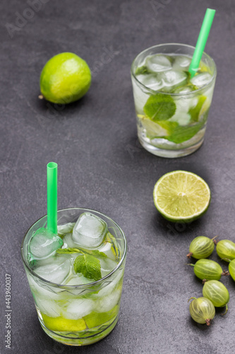 Two glasses of cold drink with lime, mint and ice.