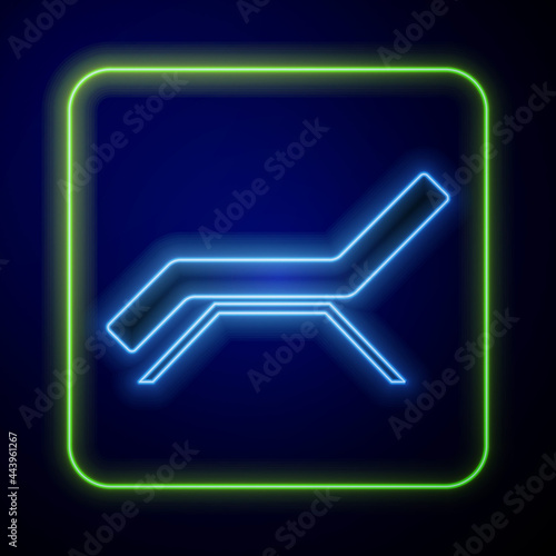 Glowing neon Sunbed icon isolated on blue background. Sun lounger. Vector